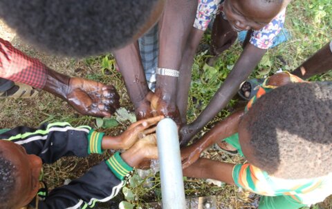 Children celebrate a repaired well as water flows for the first time in years at a healthcare facility (Photo credit: Haik Kocharian for Village Health Partnership)